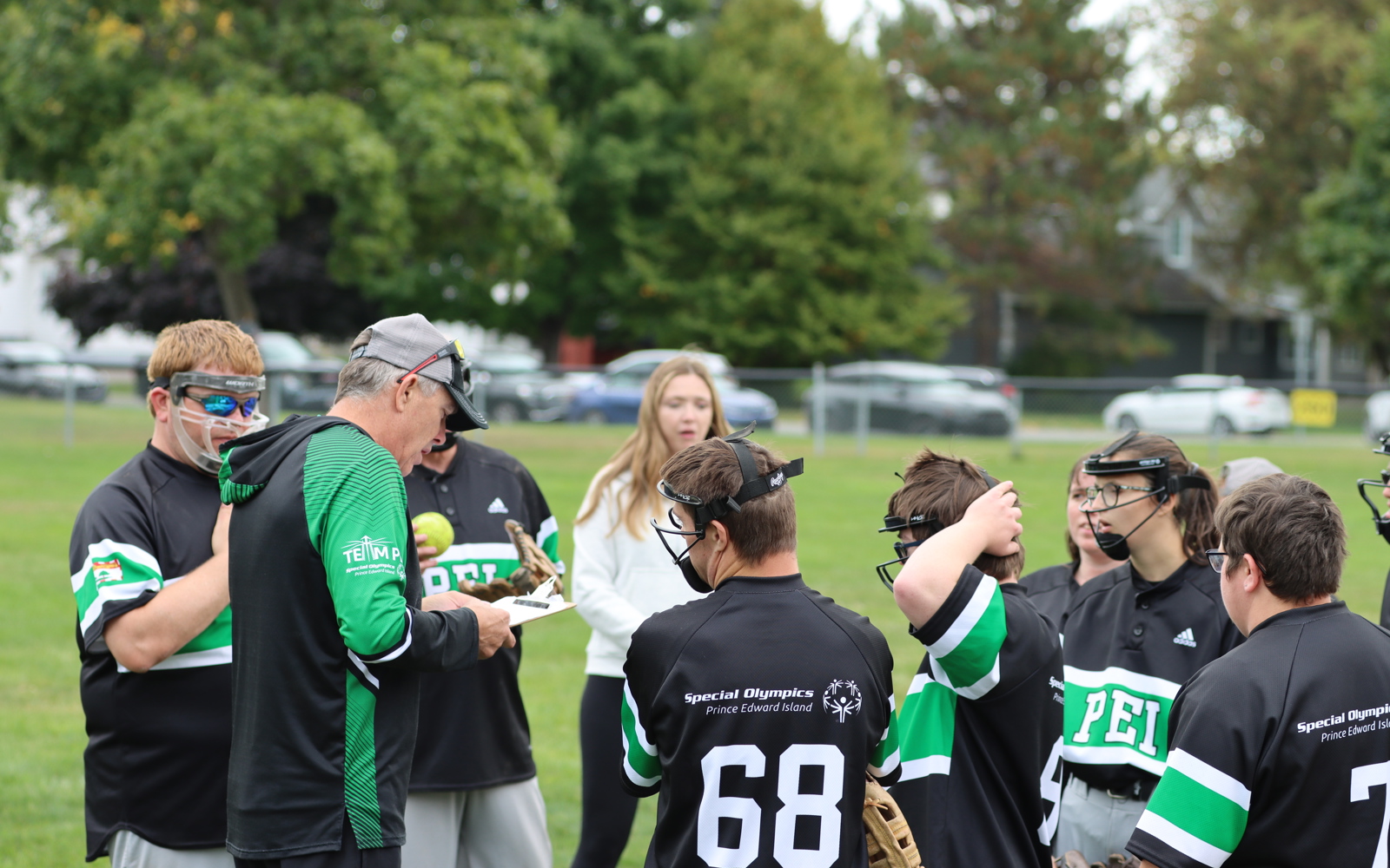 Team PEI Softball competing at the 2024 SONB Invitational, Special Olympics PEI, Softball, Coach with Group of Athletes