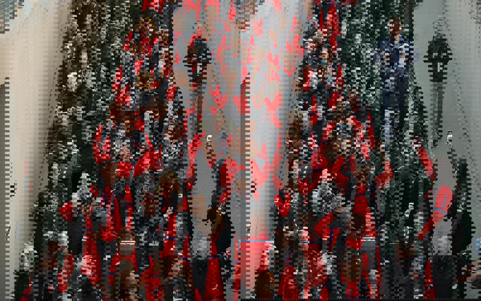 Large group of people walking. All dressed in red Canada gear.