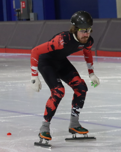 An action shot photo of a speedskater on the ice.