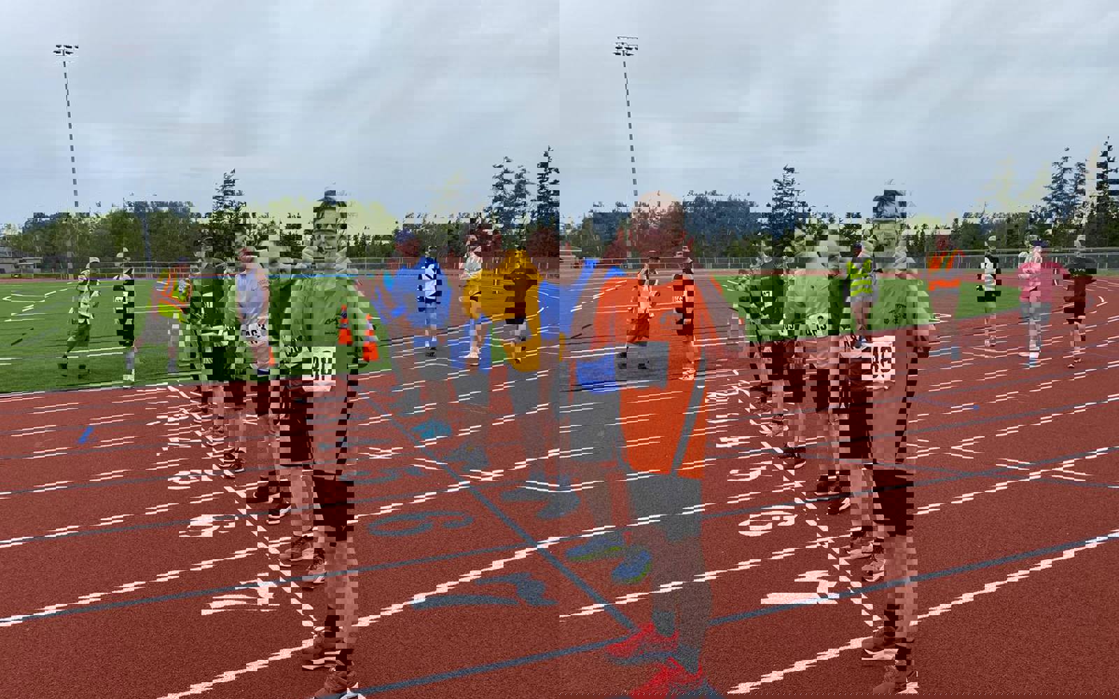 Diverse group of people standing on a race track getting ready to run a race. 