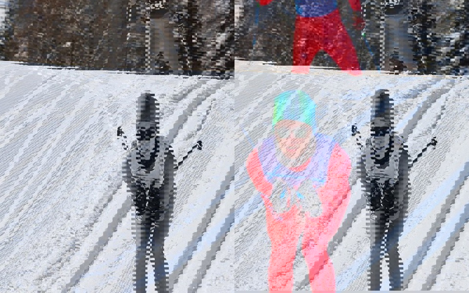 Cross country skier coming down a snowy hill, dressed all in red. 
