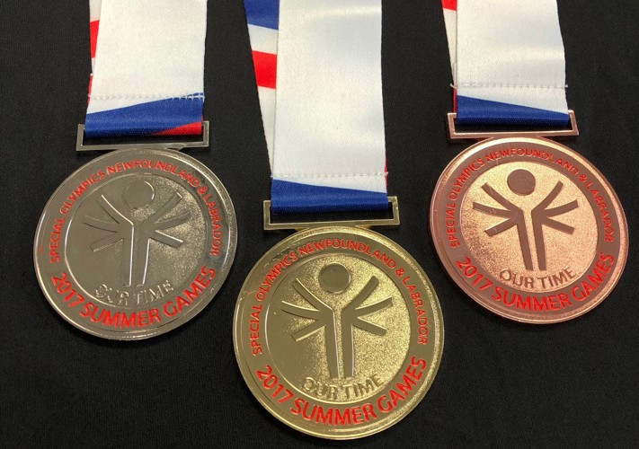 Three Special Olympics Newfoundland & Labrador medals on a black background. From left to right is a silver, gold, and bronze medal. The medals have the Special Olympics logo on it, and it reads "2017 Summer Games".