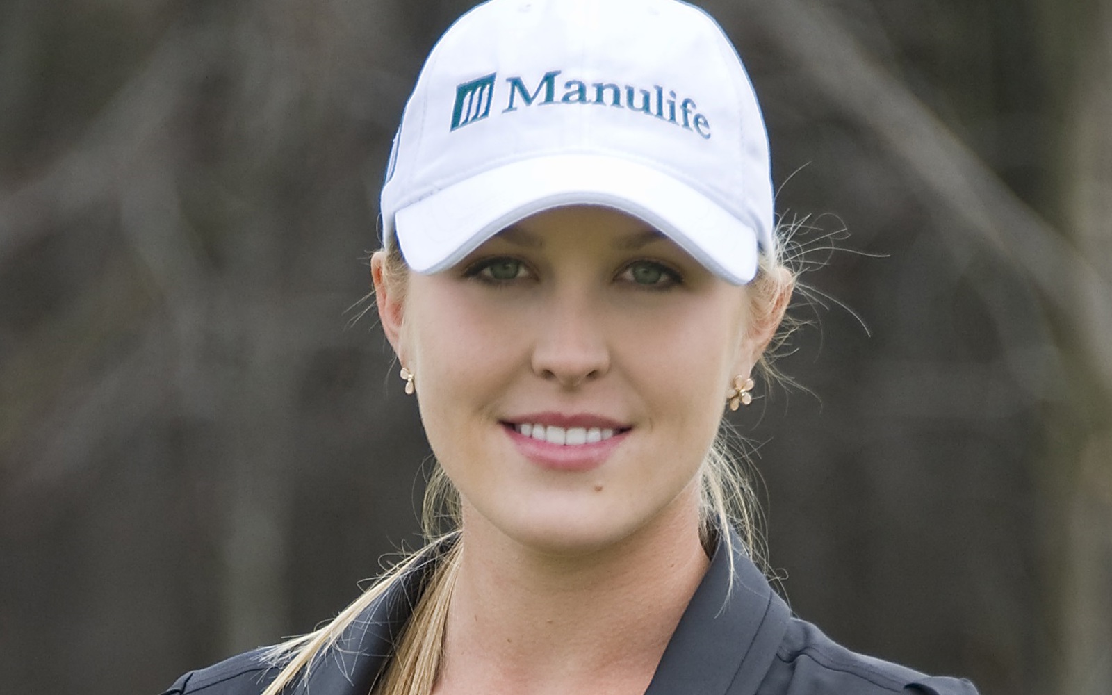 Woman with a Manulife baseball hat and a black polo shirt 