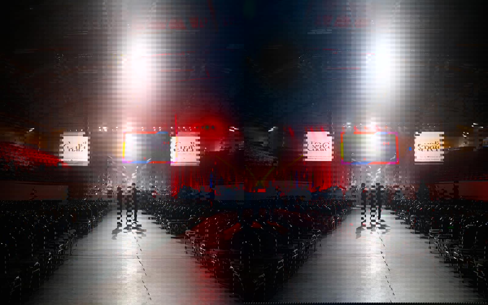 Three people standing in a crowded room with Government of Canada branding 