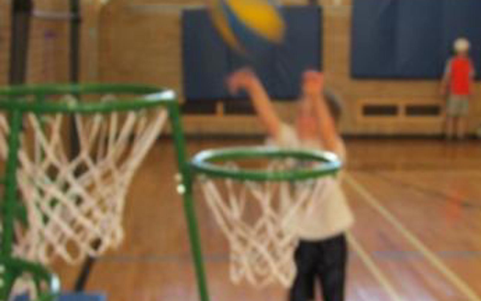Blurry photo of a small child throwing a basketball into a net