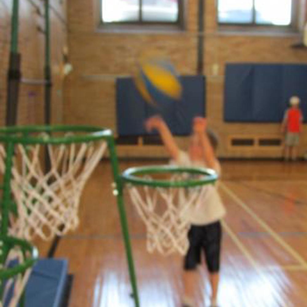 Blurry photo of a small child throwing a basketball into a net