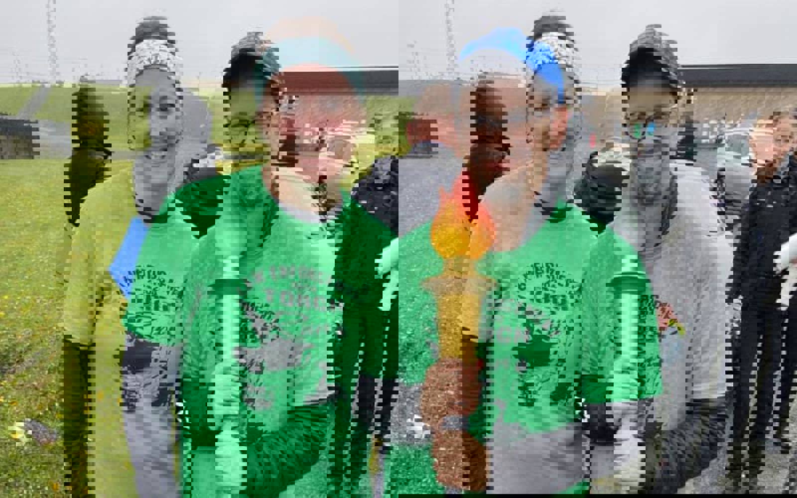 Two people standing beside each other, both in green law enforcement torch run shirts. One is holding the torch. 