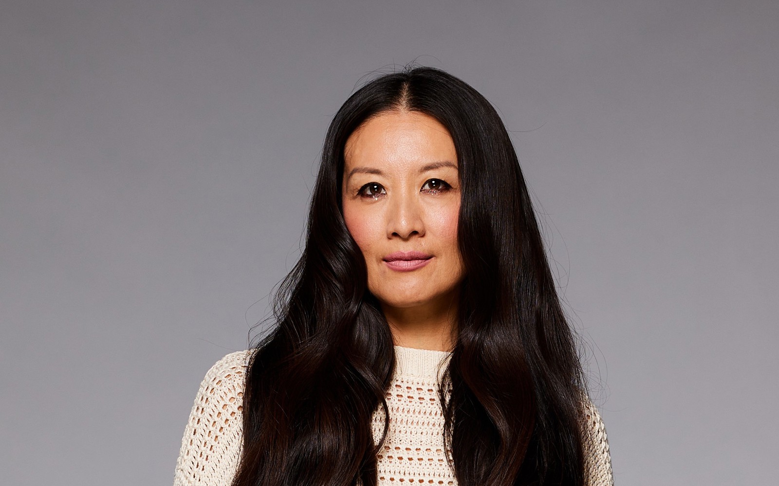 woman in long dark hair wearing a white dress. 