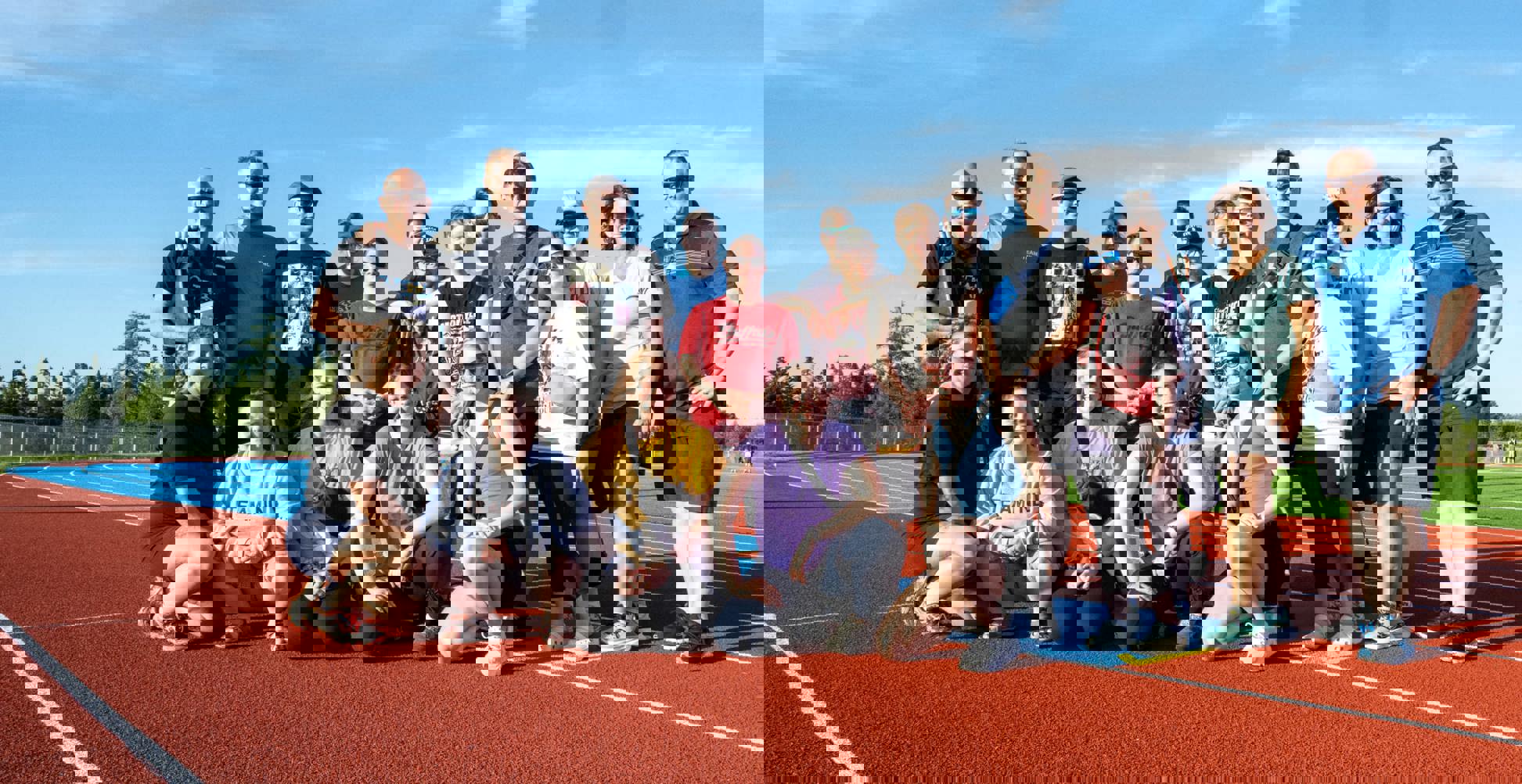 A group photo on the track. There are 19 people in the photo.