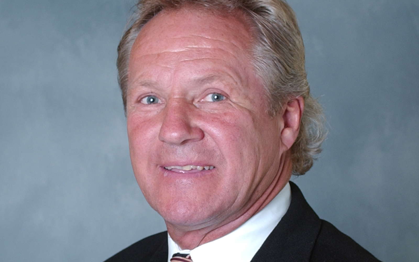 Headshot of a man in a suit.