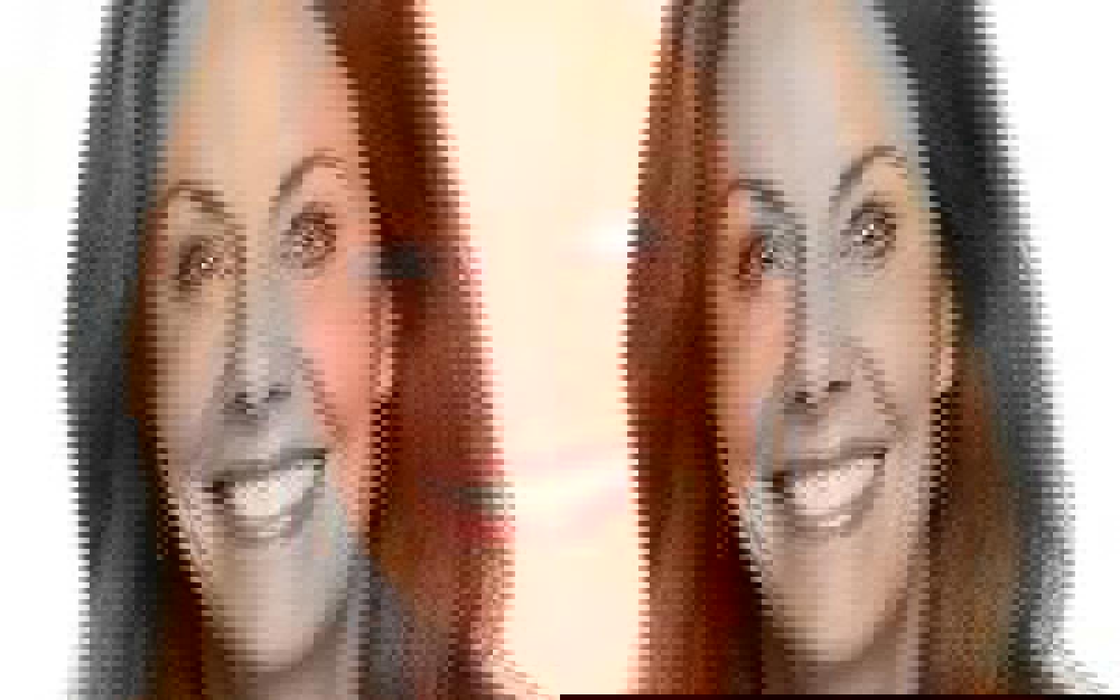 Woman with dark hair smiling at camera. 