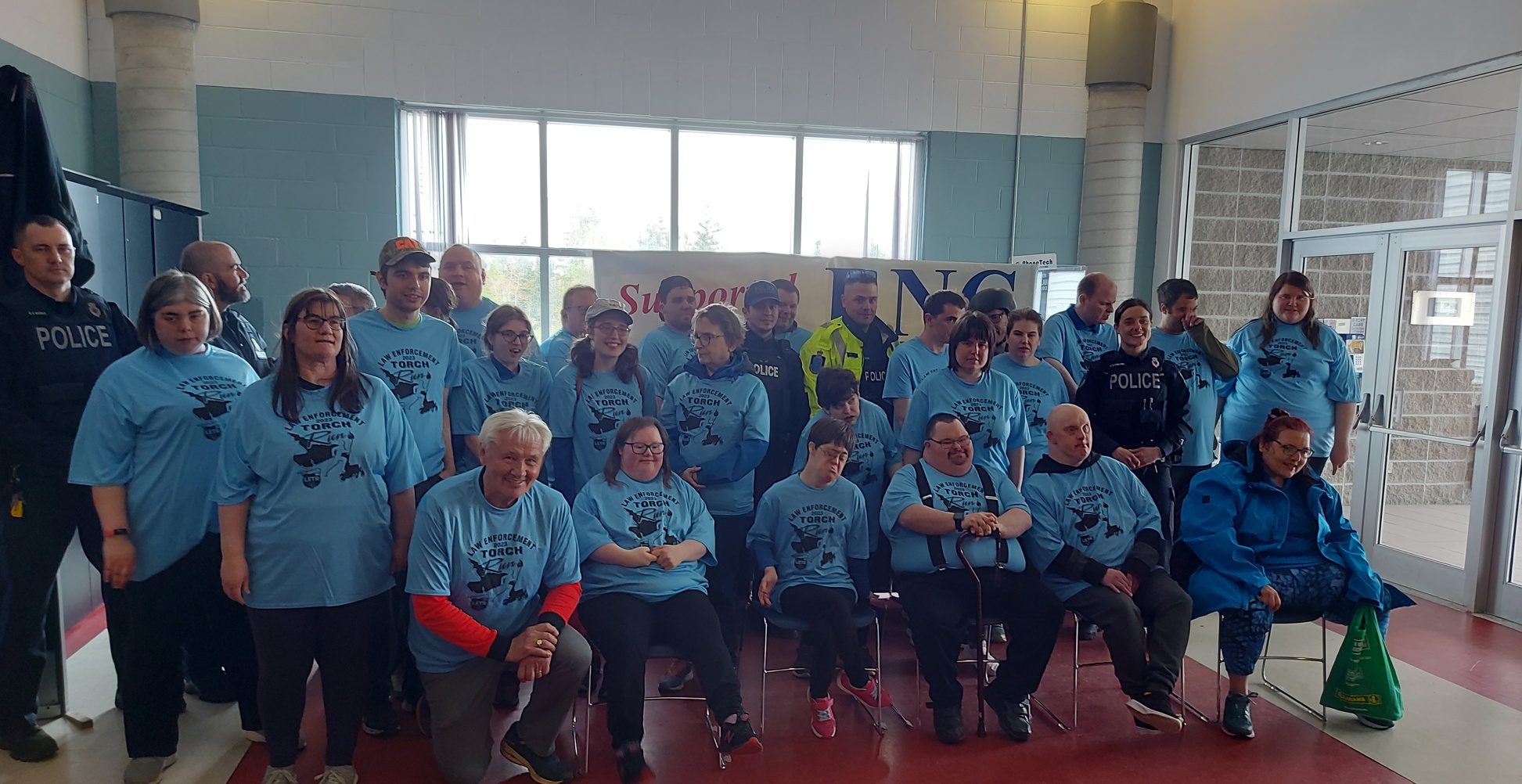 Diverse group of people wearing Law Enforcement torch Run blue shirts 