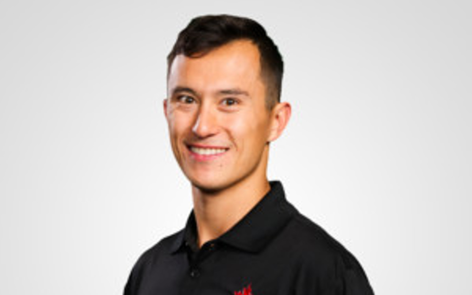 Headshot of a man wearing a black polo with the Skate Canada logo 