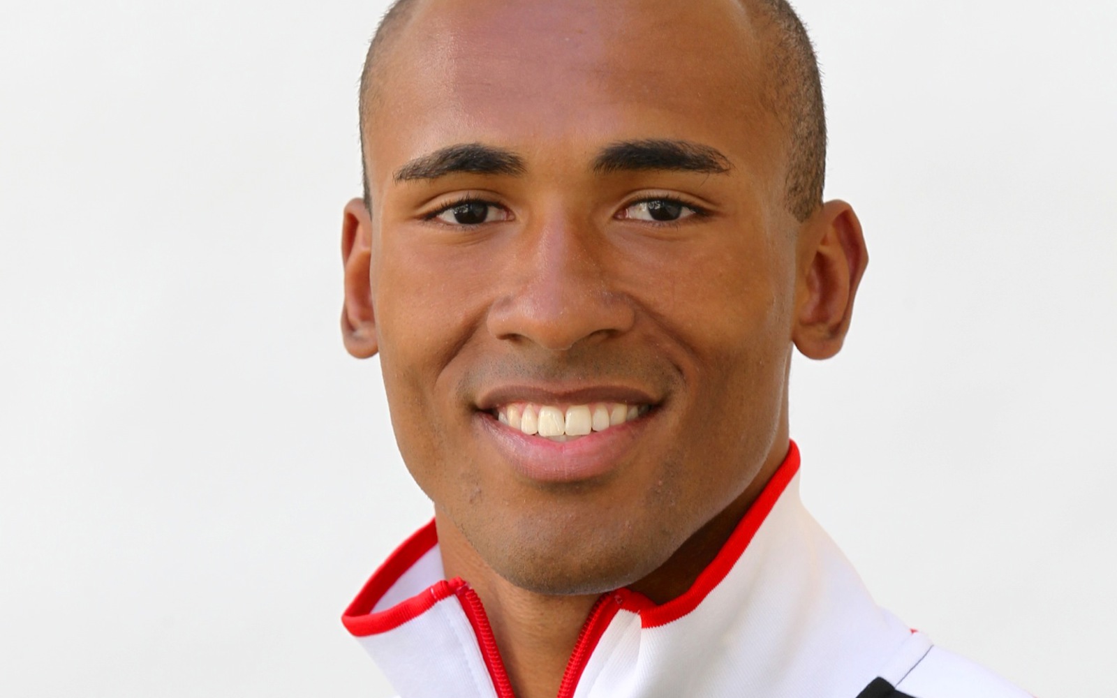 Headshot of a man in a zip up sport sweater with the Canadian flag on it. 