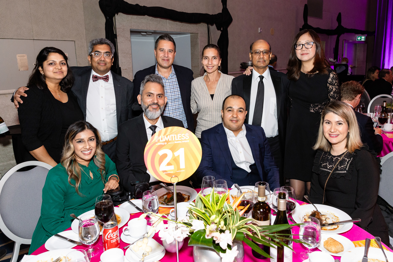 Group of people in fancy outfits sitting at a table 