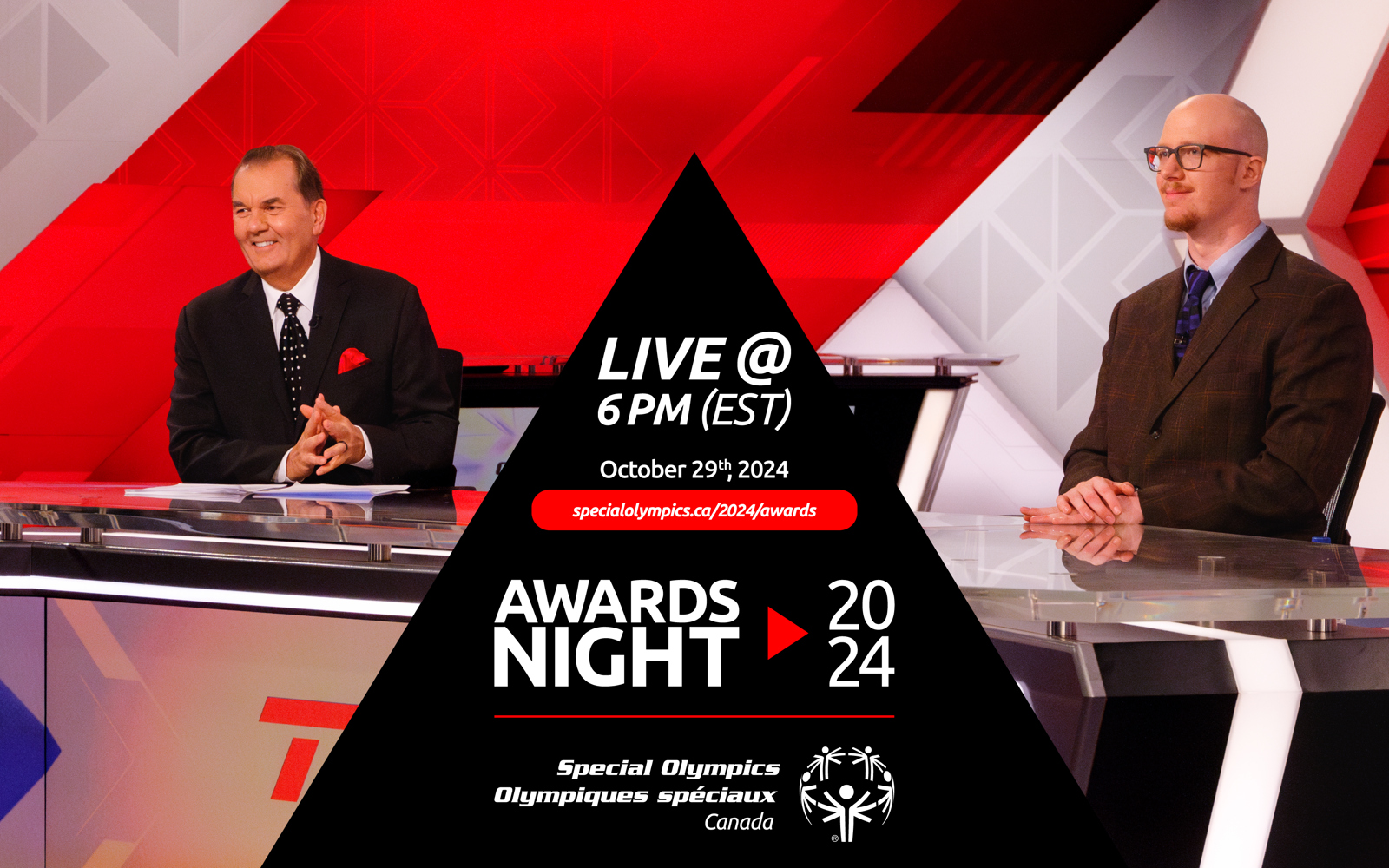 Two men in suits sit behind a news desk 