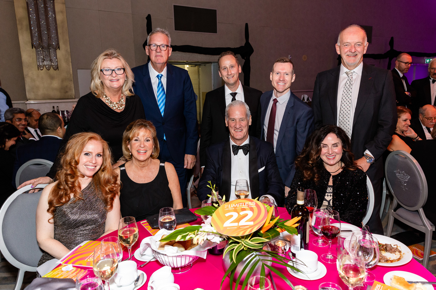 Group of people in fancy outfits sitting at a table 