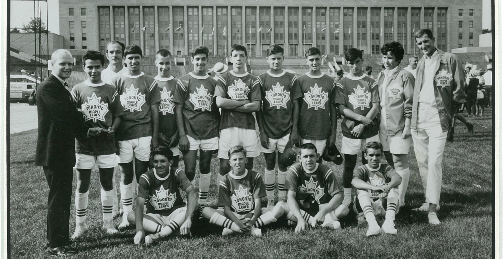 A black and white photograph of the 1968 Special Olympics Team Canada in Chicago, the team is wearing matching uniforms with Toronto Maple Leafs on the logo. The team is posing outside of the venue on a grassy field.
