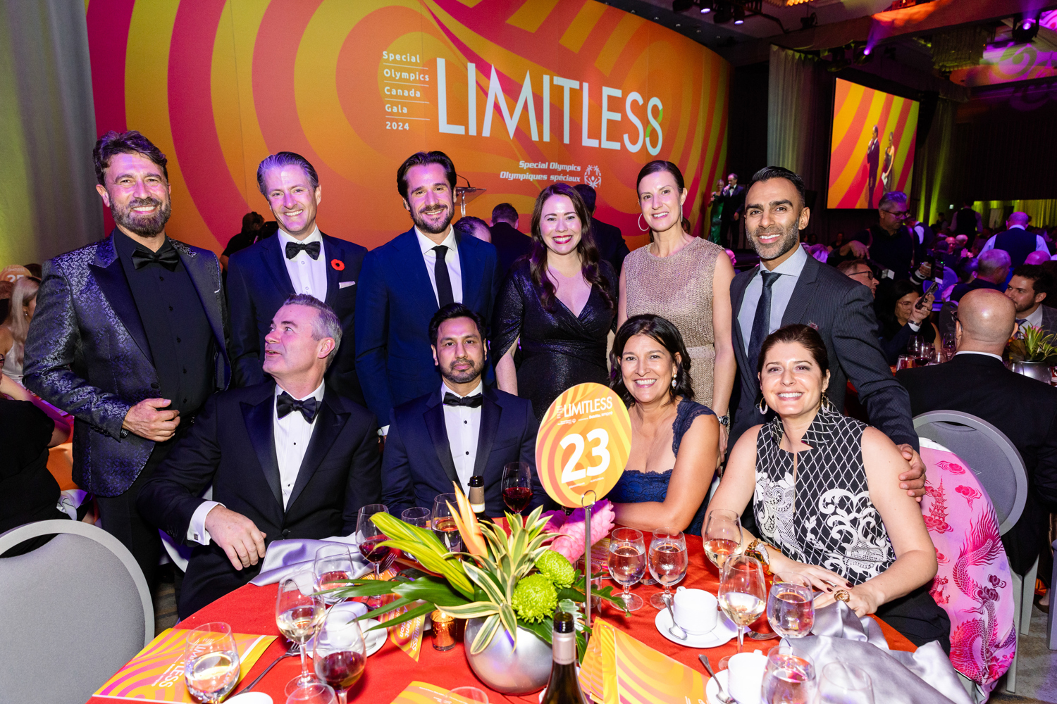 Group of people in fancy outfits sitting at a table 